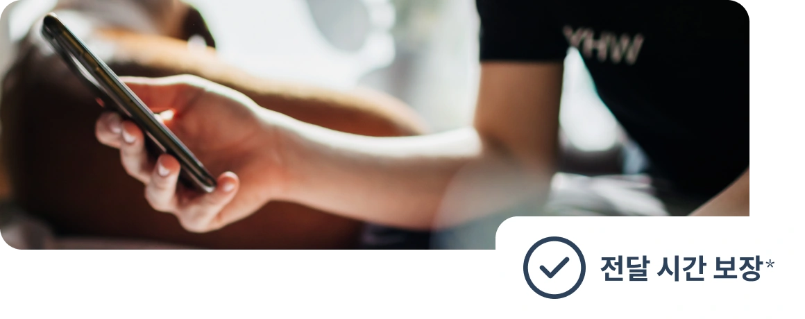 전달 보장 안내 문구가 표시된 휴대전화를 들고 있는 사용자.