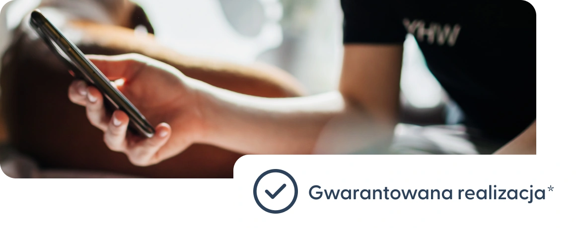 Użytkownik trzymający telefon z informacją o gwarantowanej realizacji