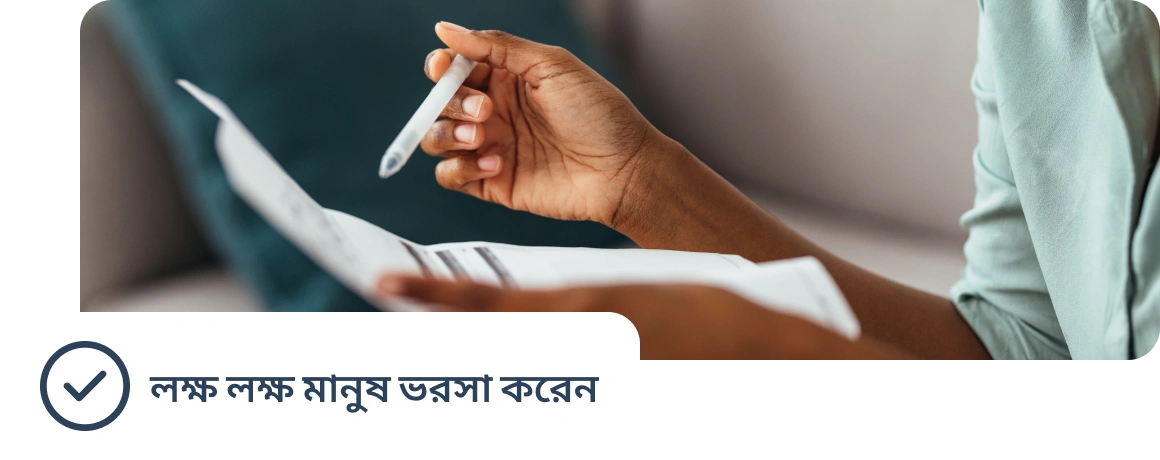 একজন ব্যক্তি হাতে করে ডকুমেন্ট ধরে রয়েছেন, যেখানে লক্ষ লক্ষ মানুষ যে ভরসা রাখেন তার উল্লেখ রয়েছে।