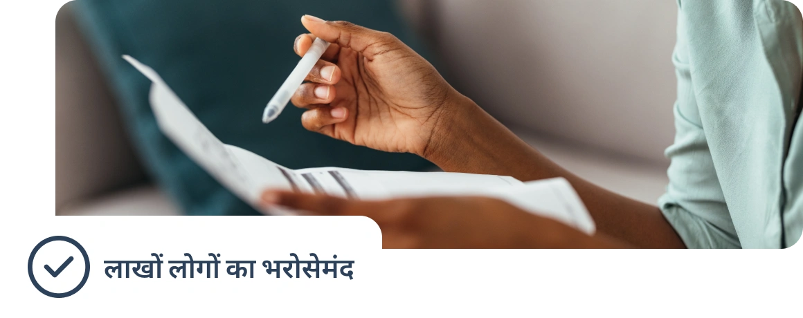 Document pakde huye ek vyakti, jis par laakhon logon ka trusted hone ka note dikh raha hai.