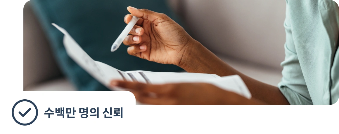 수백만 명의 신뢰를 받고 있다는 문구가 포함된 서류를 들고 있는 사람.