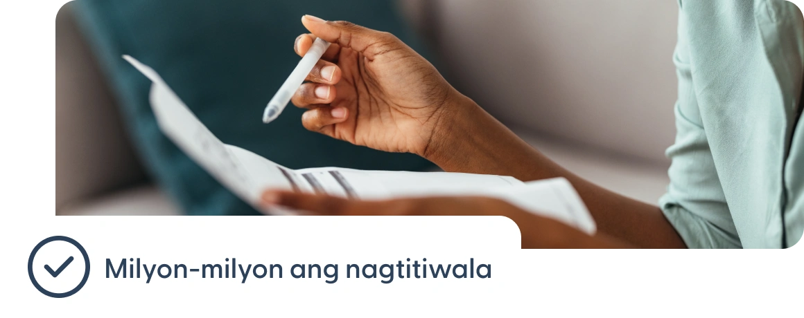 Isang taong may hawak na mga dokumento na may tala tungkol sa pagiging pinagkakatiwalaan ng milyon-milyon.