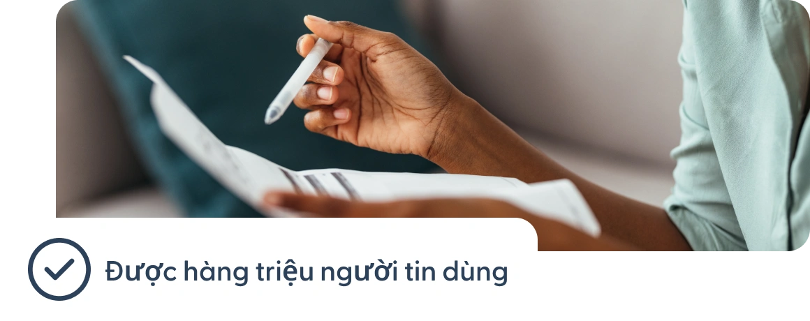 Người đang cầm tài liệu với ghi chú về việc có hàng triệu người tin tưởng.