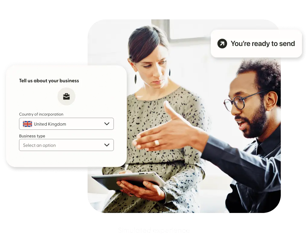 Two professionals discuss while filling out information on a tablet.
