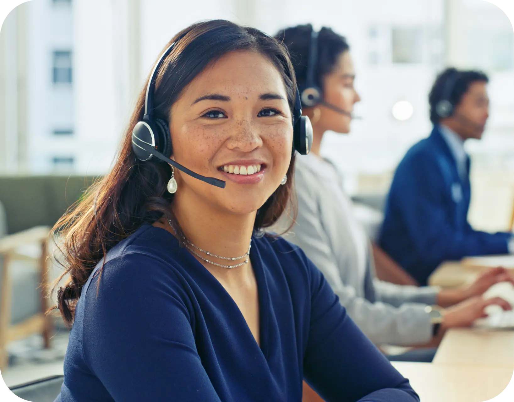 Agente de servicio al cliente con auriculares sonriendo.