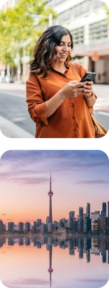 Woman smiling at her phone above a view of Toronto's skyline at sunset.