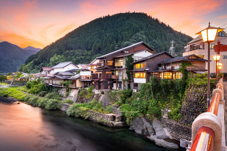 Gujo Hachiman hot springs town at dusk, reflected over the Yoshida River in Gifu prefecture.