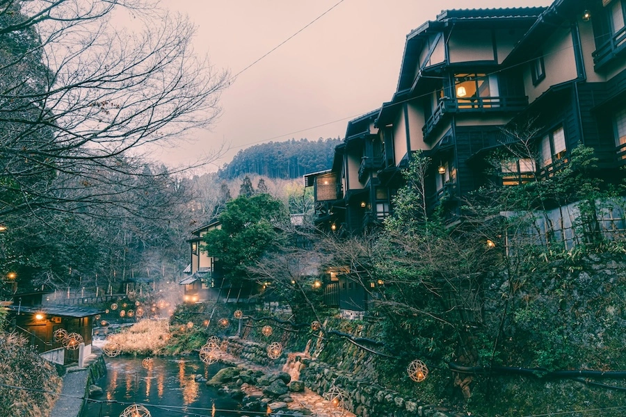 Riverside traditional inns and lanterns in Minamioguni, Japan, at dusk.