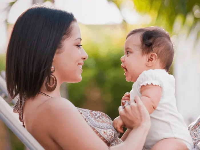 A woman smiling at an infant