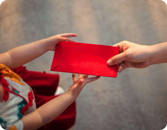 A red envelope being exchanged between two people.