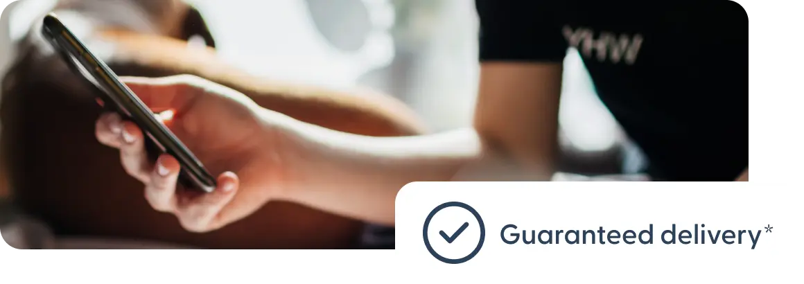 전달 보장 안내 문구가 표시된 휴대전화를 들고 있는 사용자.