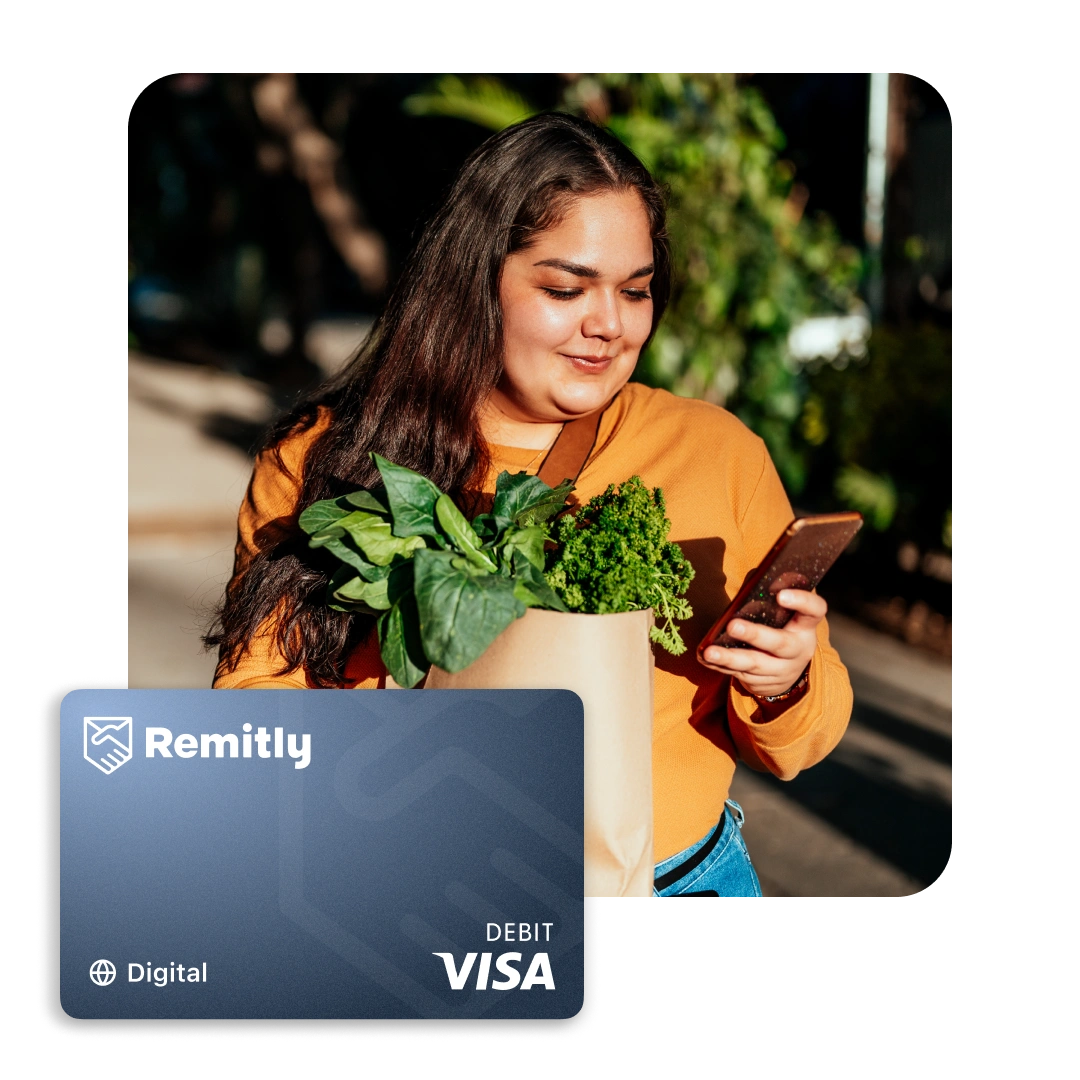 Persona sosteniendo víveres mientras revisa un teléfono con Remitly Card.